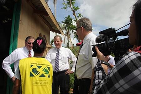 Presiding Bishop Gary E. Stevenson and other Church leaders visit with a Philippine typhoon victim in Tacloban.