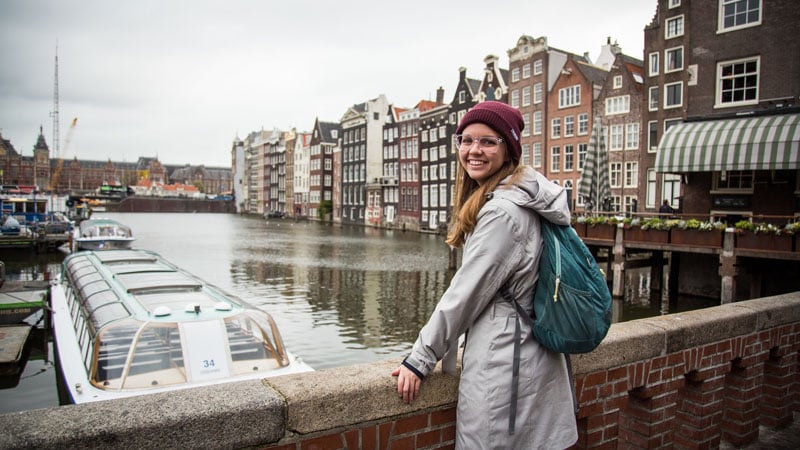 BYU female student smiling and standing on a bridge on a BYU study abroad.