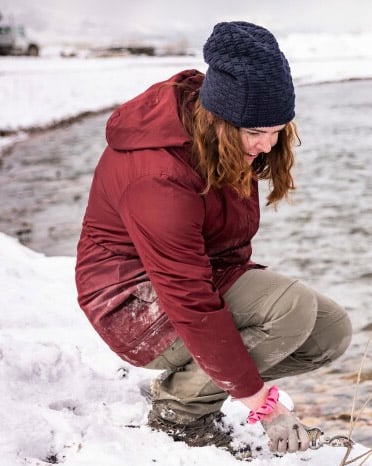 Anna Monson, a BYU biology student, outside by a creek in winter