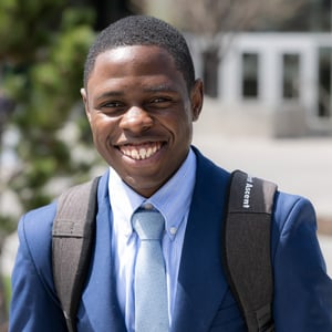 Smiling African American BYU-Idaho student outdoors in navy blue suit and tie